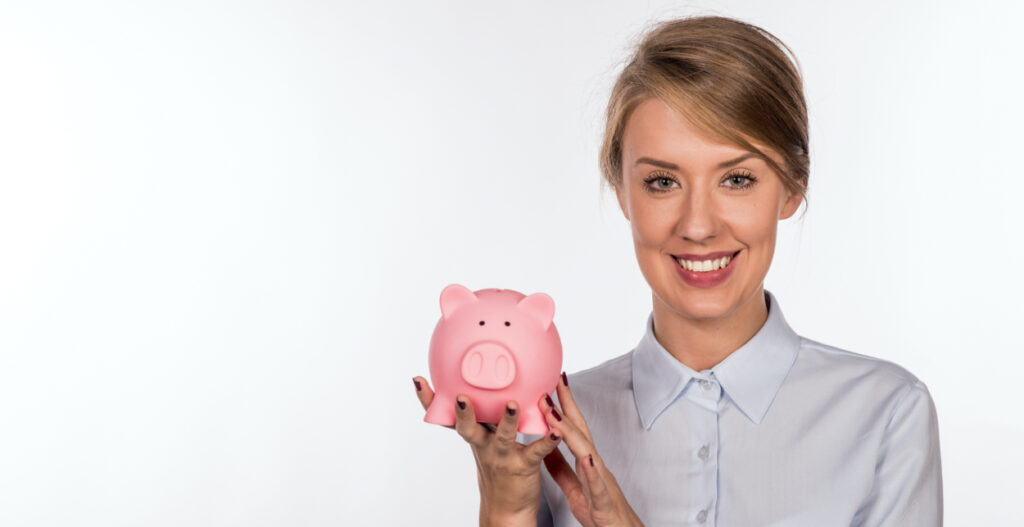 Mulher segurando um porquinho para guardar dinheiro e ilustrar matéria sobre benefícios
