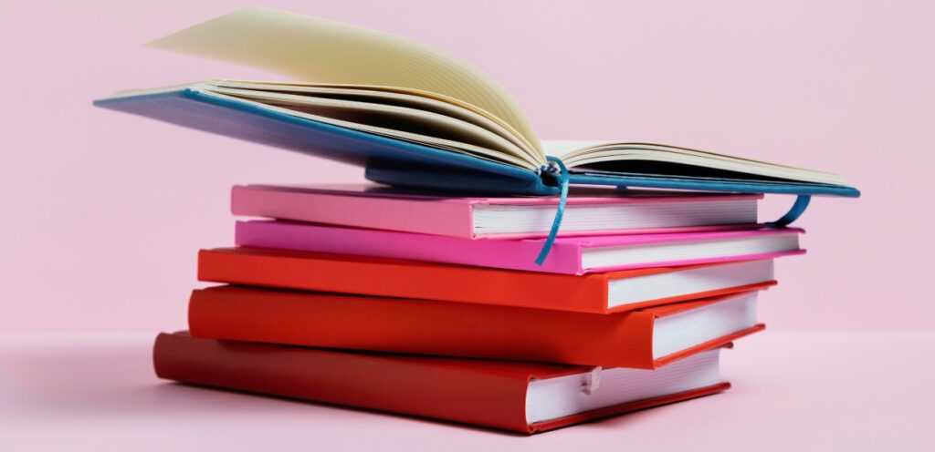 Livros de RH empilhados em mesa