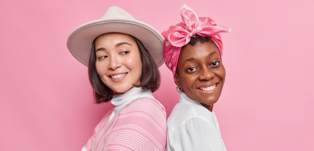 duas mulheres jovens em um fundo rosa para representar a Geração Z no mercado de trabalho