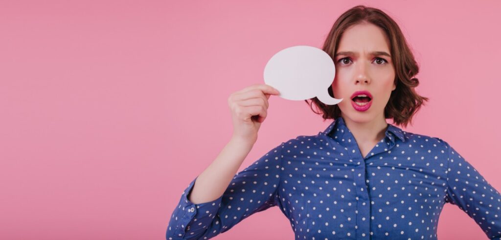 feedback: imagem mostra mulher segurando balão de mensagem, em um plano de fundo cor de rosa.