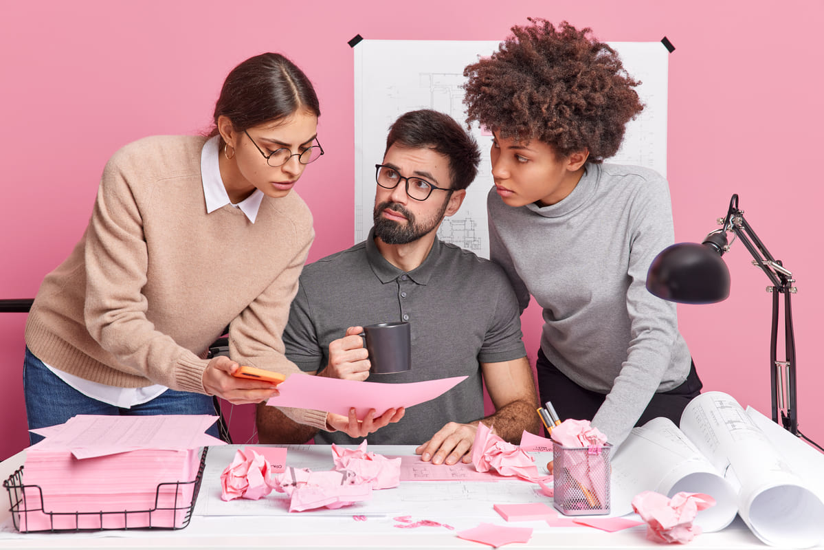 Equipe reunida analisando documentos sobre estratégias de gestão de pessoas.