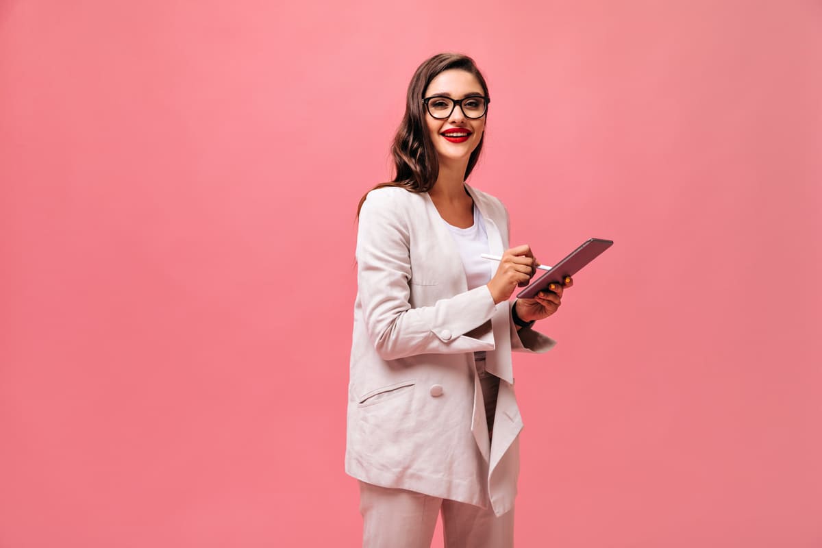 Profissional sorridente com tablet apresentando tipos de benefícios corporativos.